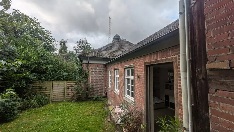 Bâtiment ferroviaire en brique, avec jardin et ouvertures régulières