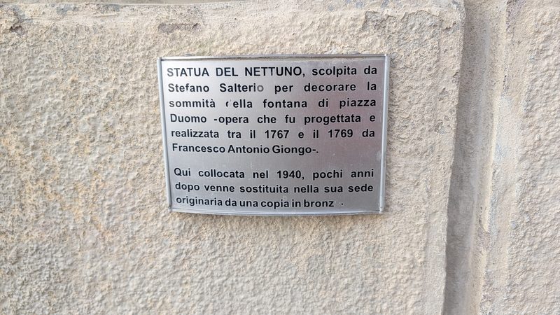 Plaque explicative de la statue de Neptune.