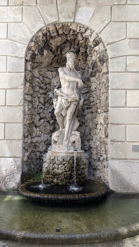 Statue originale de Neptune dans une niche en pierre.