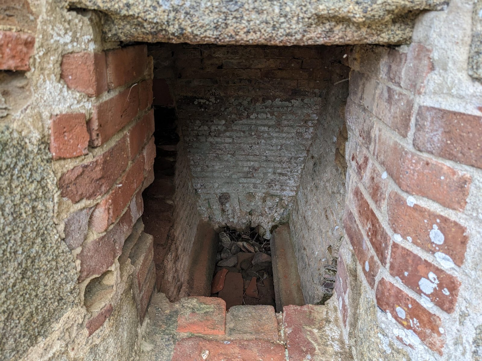 Vue à l’intérieur du four à rougir les boulets du Fort La Latte, montrant la maçonnerie en briques et le conduit de chauffe.