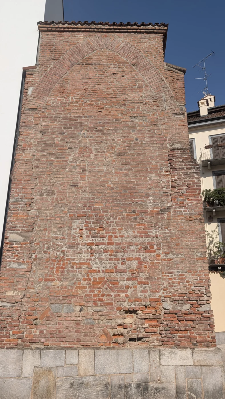 Grand arc aveugle visible dans le mur médiéval en briques du Palazzo Gorani à Milan.