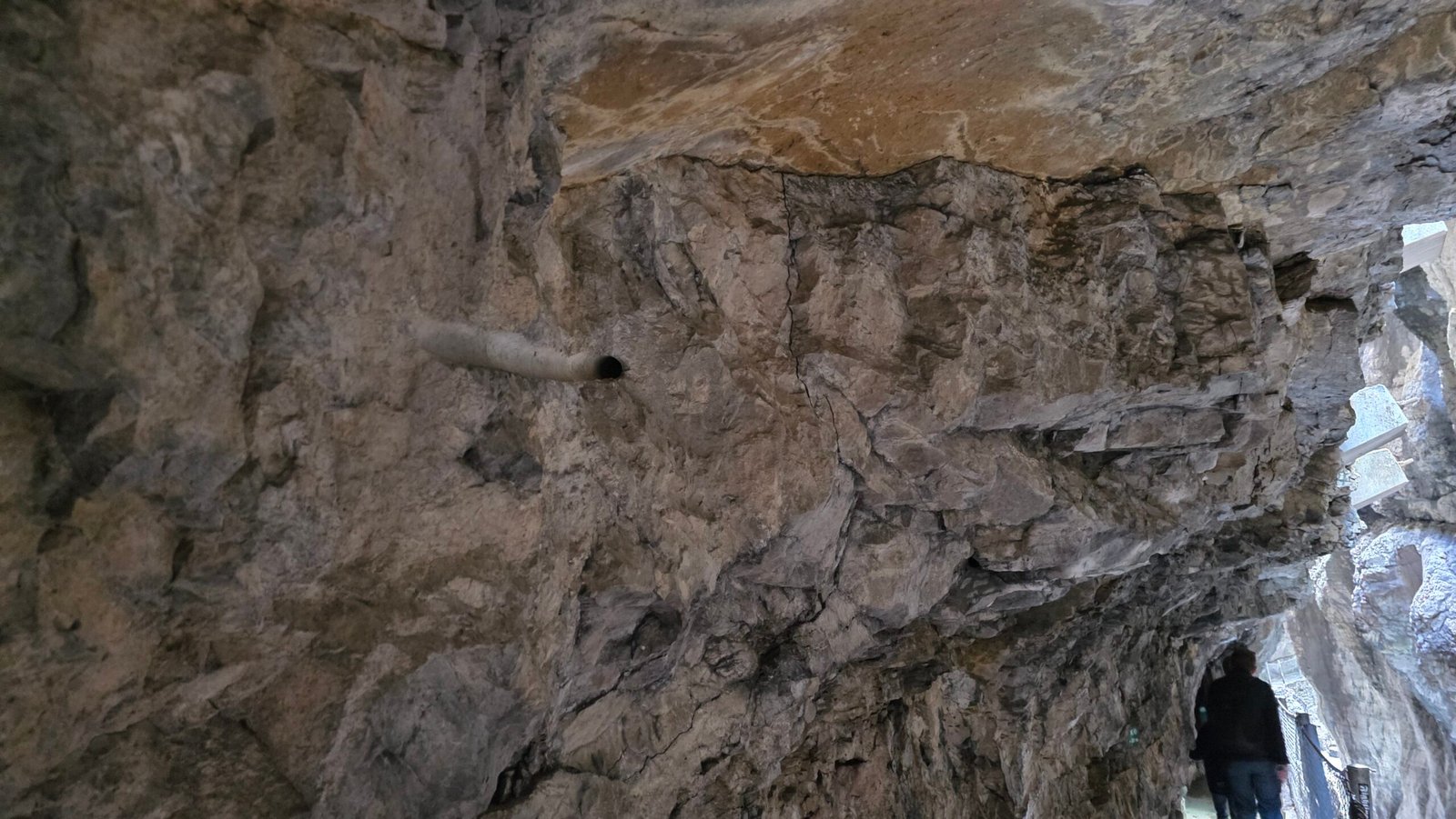 Détail de la paroi rocheuse du passage, avec aménagements métalliques visibles.